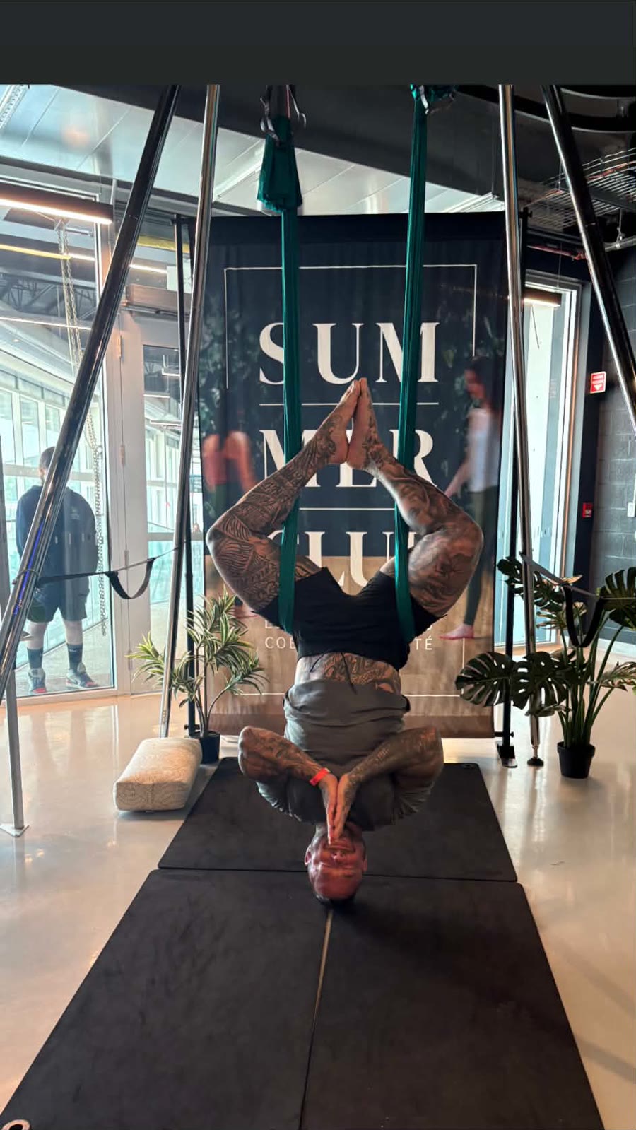 Le propriétaire de Zenovia, la tête en bas dans un hamac de yoga aérien